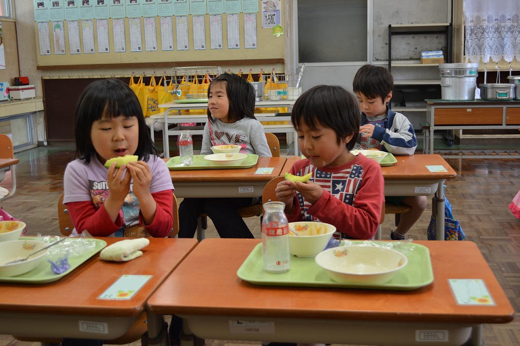 給食でアンデスメロンを食べる児童の写真