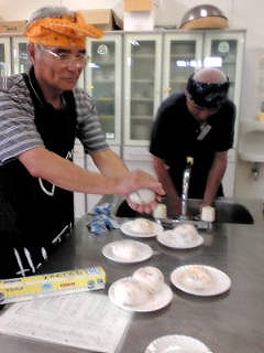 男性料理教室で料理をする男性二人の写真