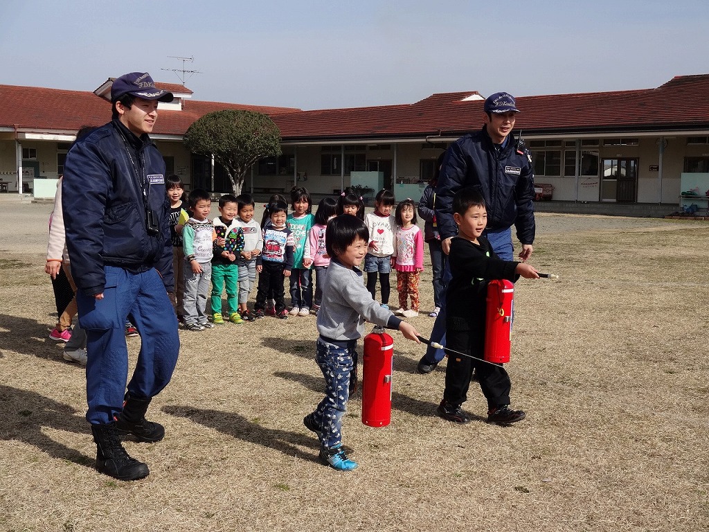 合同訓練で消火器を持つ園児たちの写真